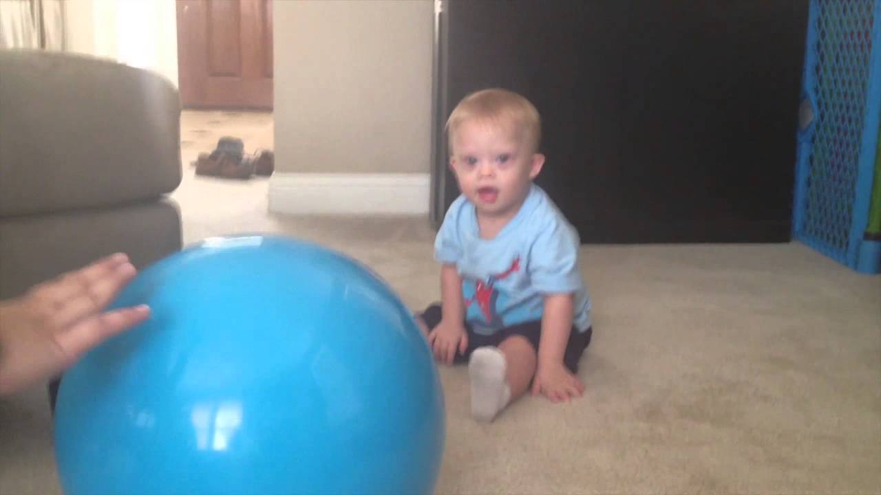 Baby With Down Syndrome Playing With A Ball With His Dad