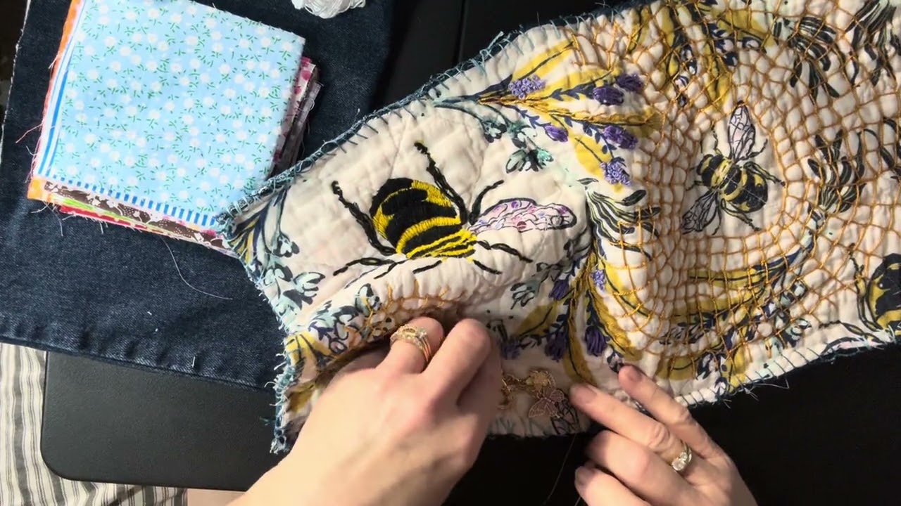 Slow stitching on my journal cover adding a bead and dangles 