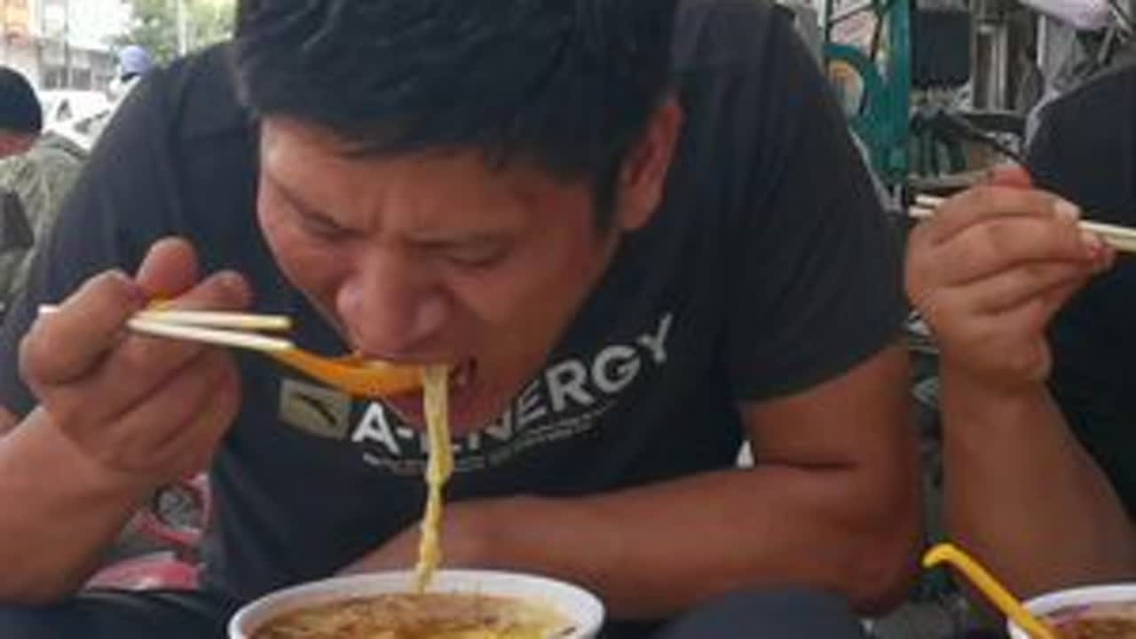 坐在街头吃油饼喝母鸡汤，一口油饼，一口汤，得劲！