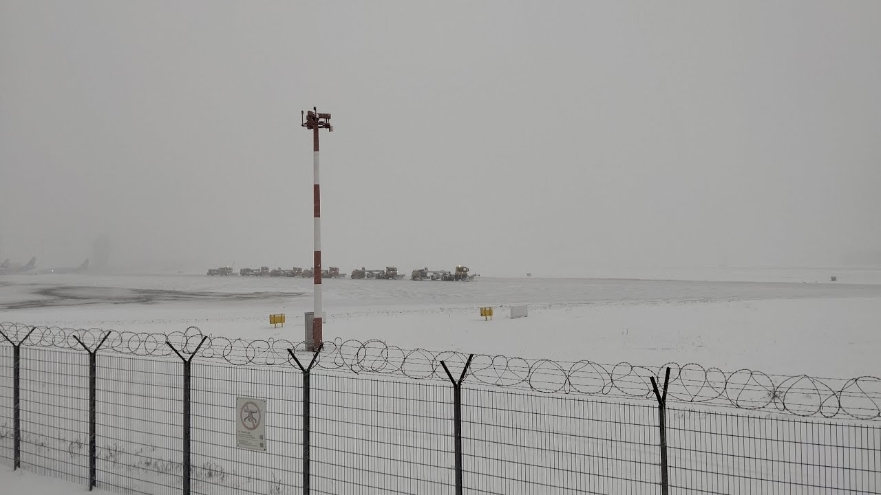 Clearing snow from the runway after a snowstorm. Katowice airport (Poland)