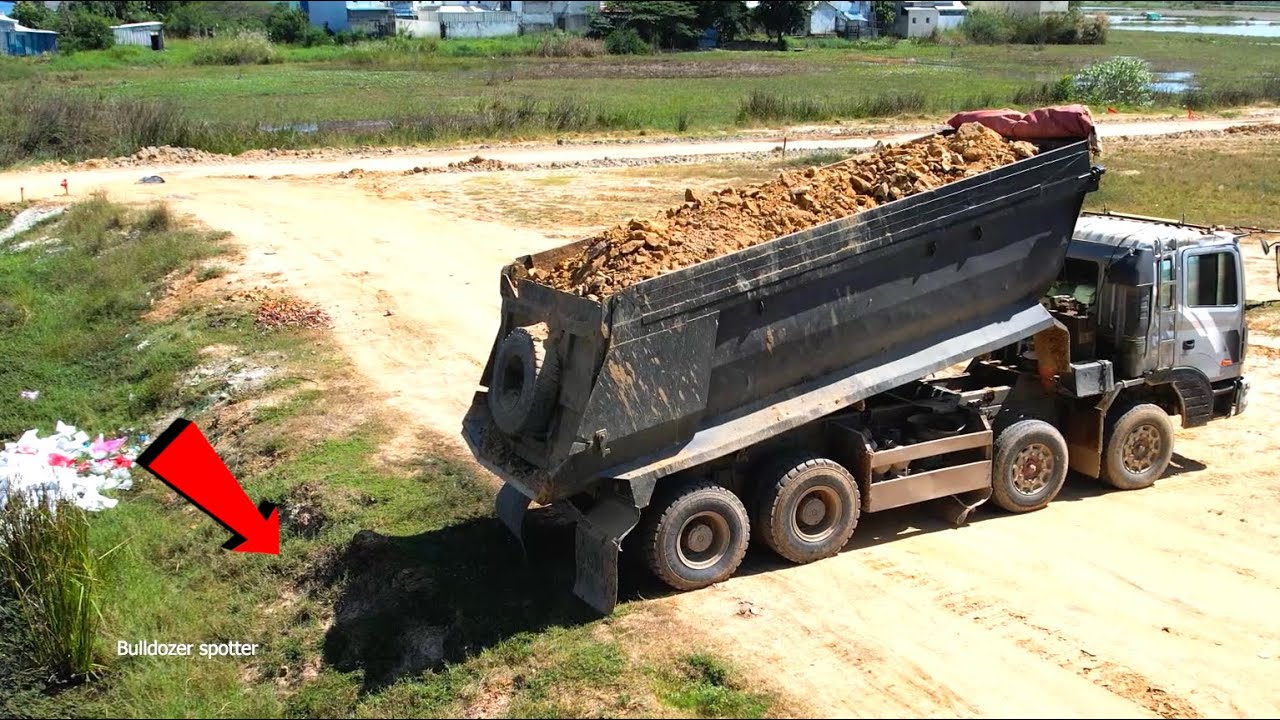 Incredible heavy dump truck 25T unloading soil landfilling and Bulldozer Komatsu D41P working push 