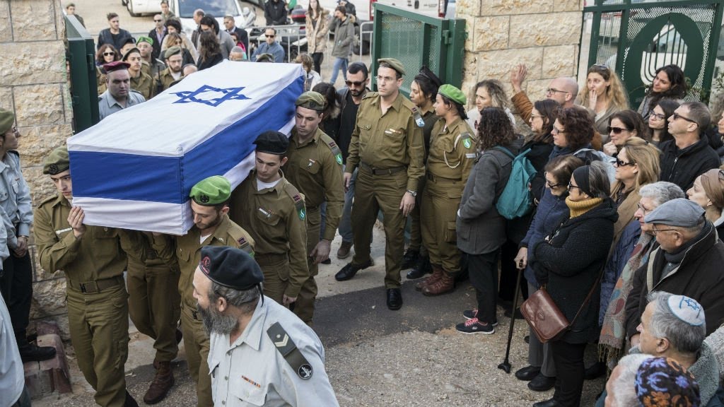 Israel: authorities bury truck attack victims amid doubts over IS group link