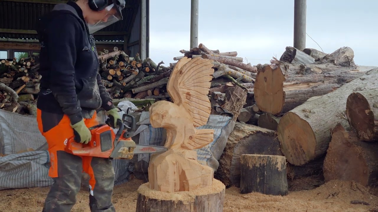 Chainsaw Carving a Short Eared Owl landing on a rock