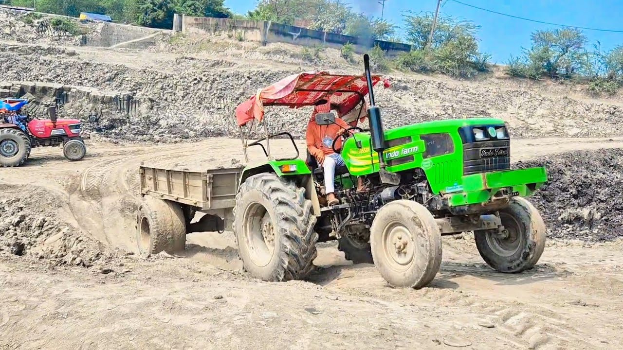 JCB TATA HITACHI machine loading mud in Indofarm Mahindra and Powertrac Tractor 
