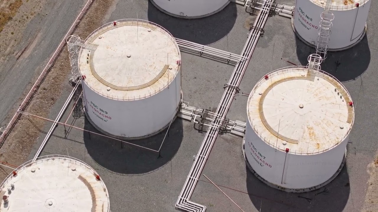 fuel storage facility with white cylindrical tanks, drone view