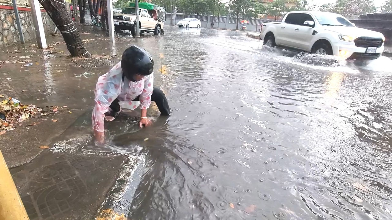 Activities to remove leaves from clogged drains to drain water along the street