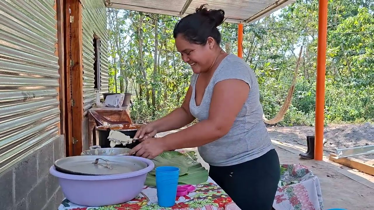 Doña maili embolviendo tamales en su casa. 