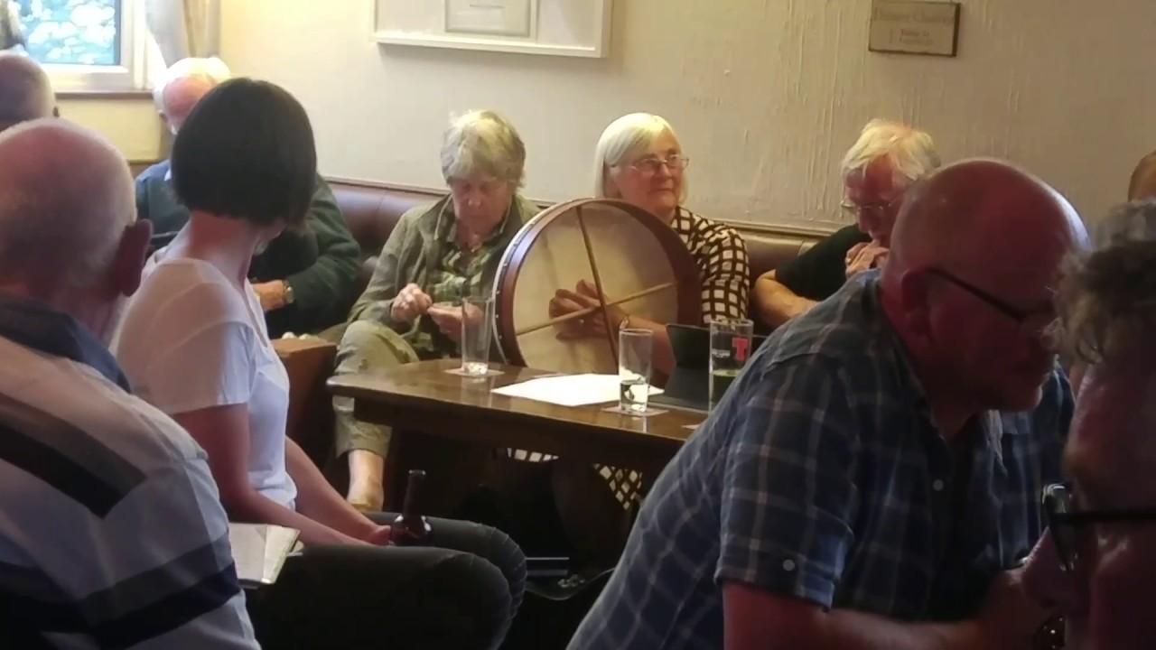 An impromptu folk music jam session at a Scottish pub.
