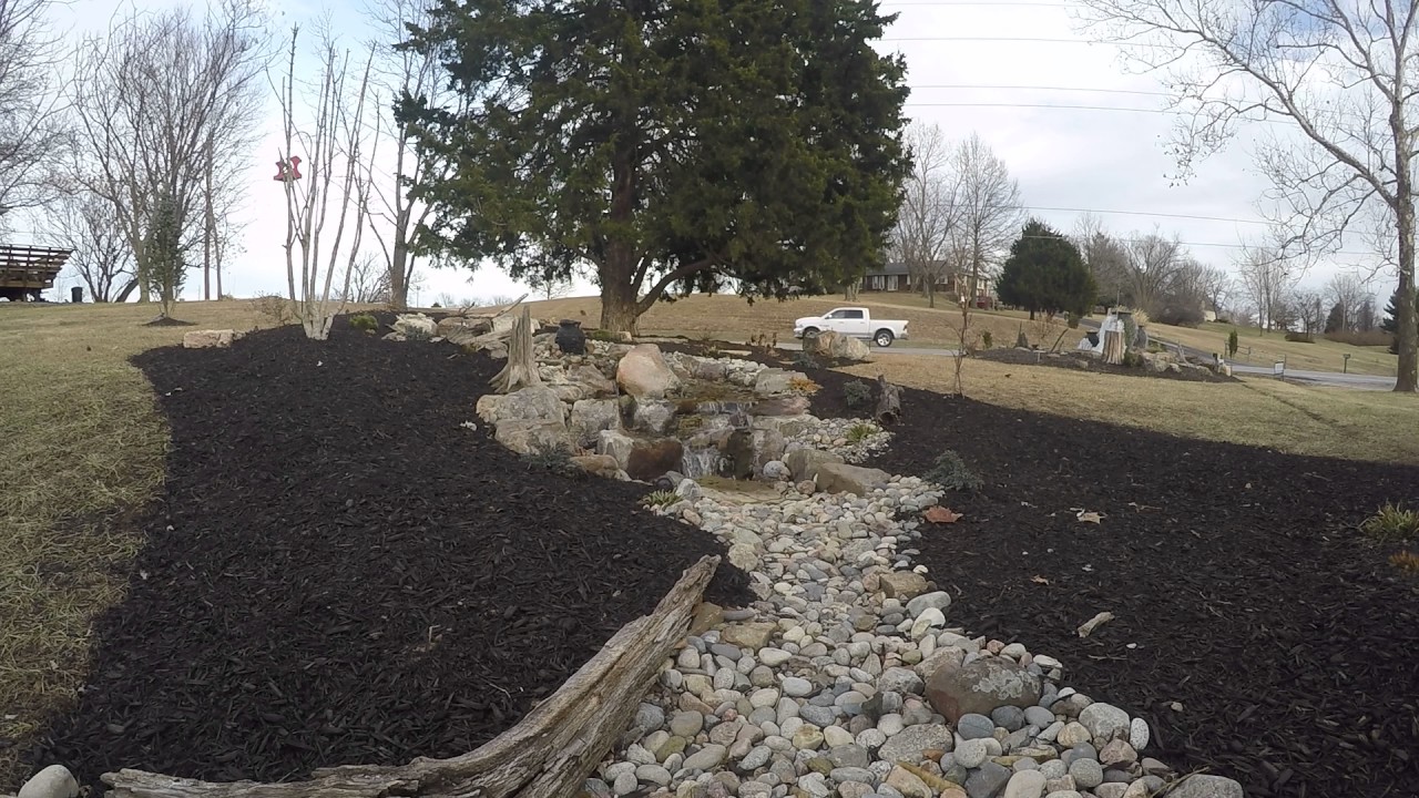 Footage of birds during the winter eating, drinking and bathing near a water feature.