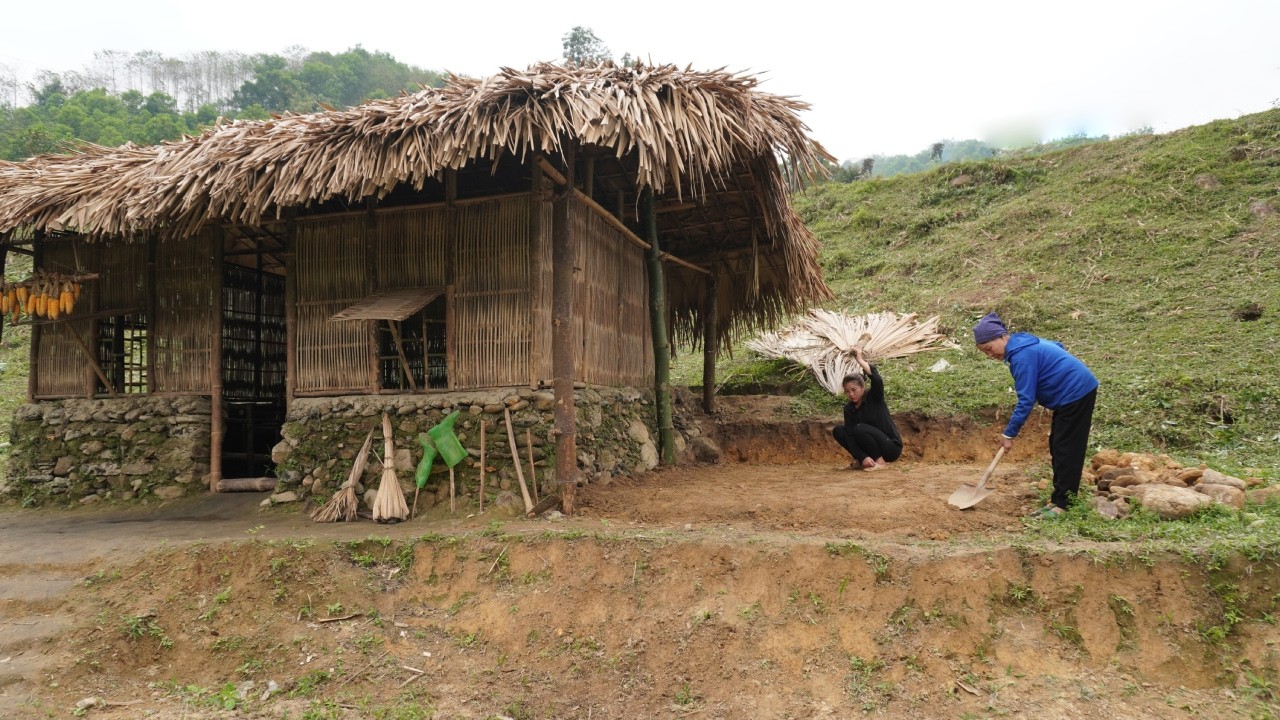 Tieu Nhu and her grandmother are cleaning up and digging the soil to make foundations.