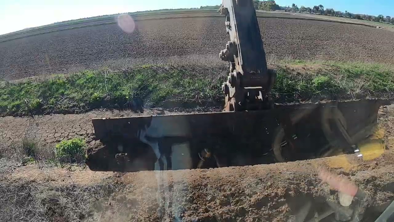 Excavator & 12ft grader blade removing silt from water supply ditch