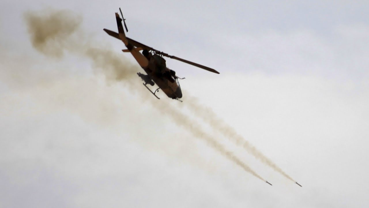 AH-1F Cobra helicopters firing rockets in raid rehearsal