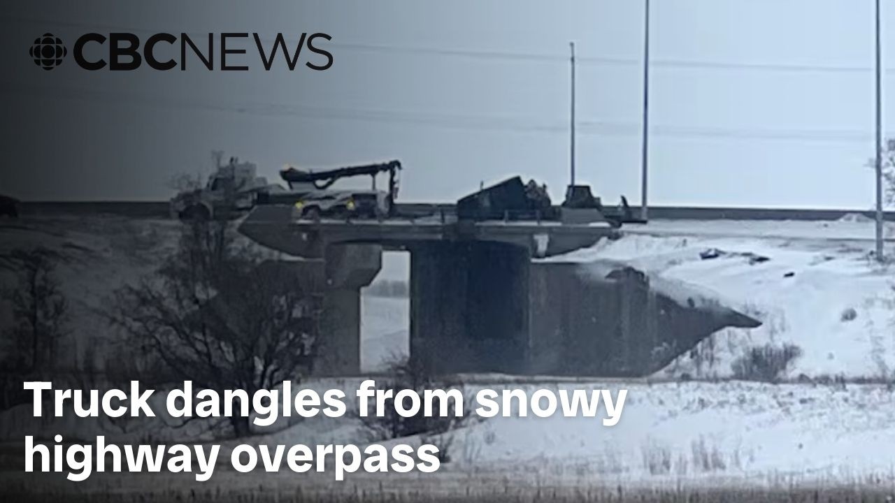 Truck dangles from snowy highway overpass in Winnipeg after crash