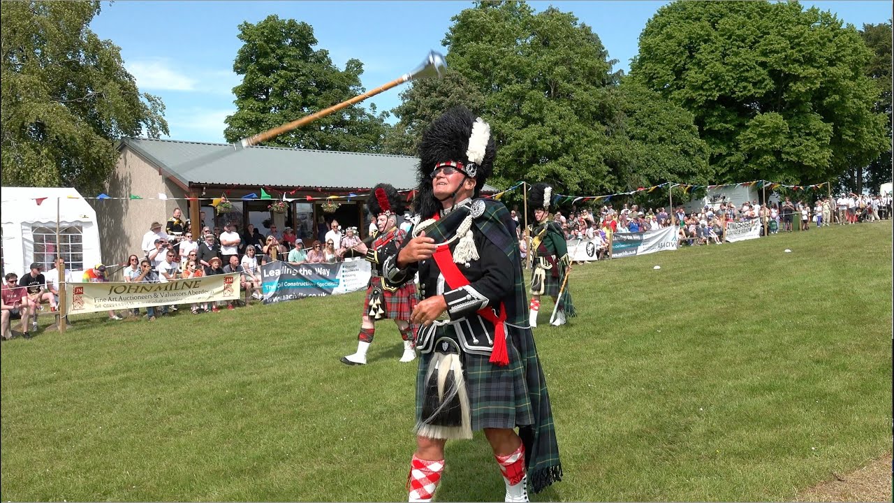 Drum Majors Mace flourish (spin) competition on the march during 2023 Oldmeldrum Highland Games
