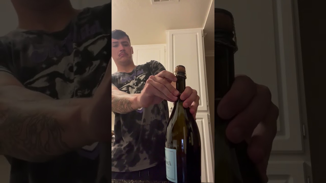 Guy Carefully Opens Bottle Of Champagne Cork Pop