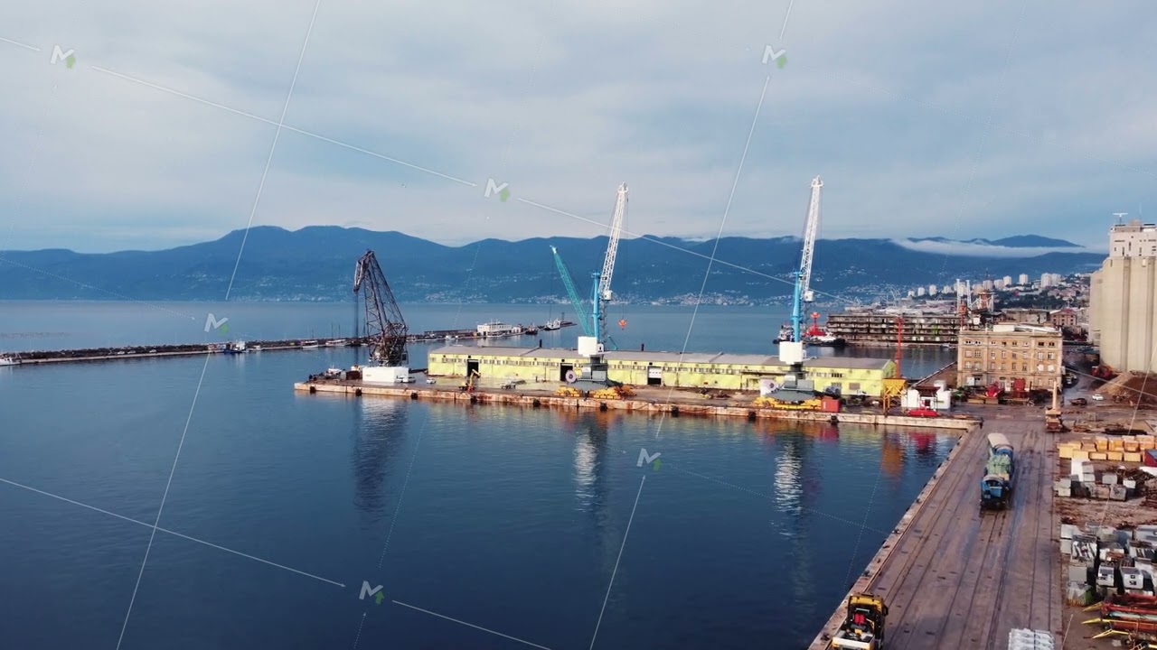 Drone view of the cargo seaport and huge port cranes. Handling dock for ships, dry cargo ships