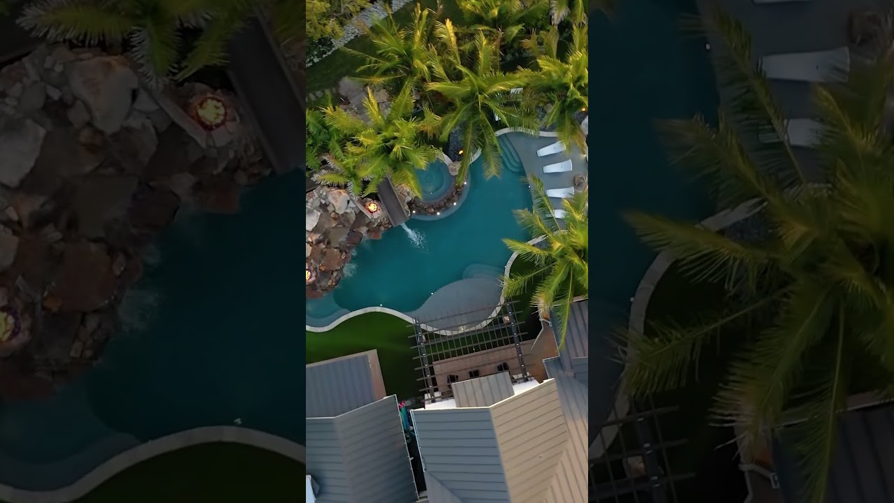 This backyard has an amazing slide, natural rock grotto, sunken fire pit, spa, putting green. #pool