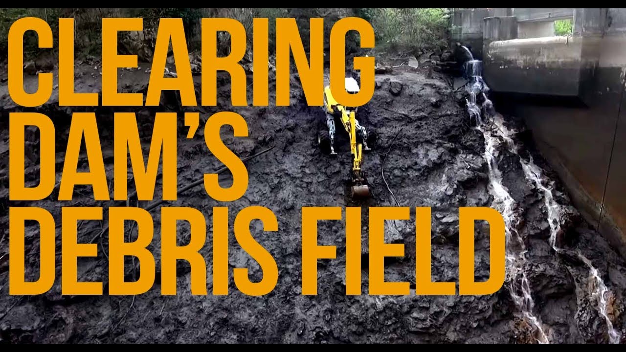Excavating bottom of dam's debris field