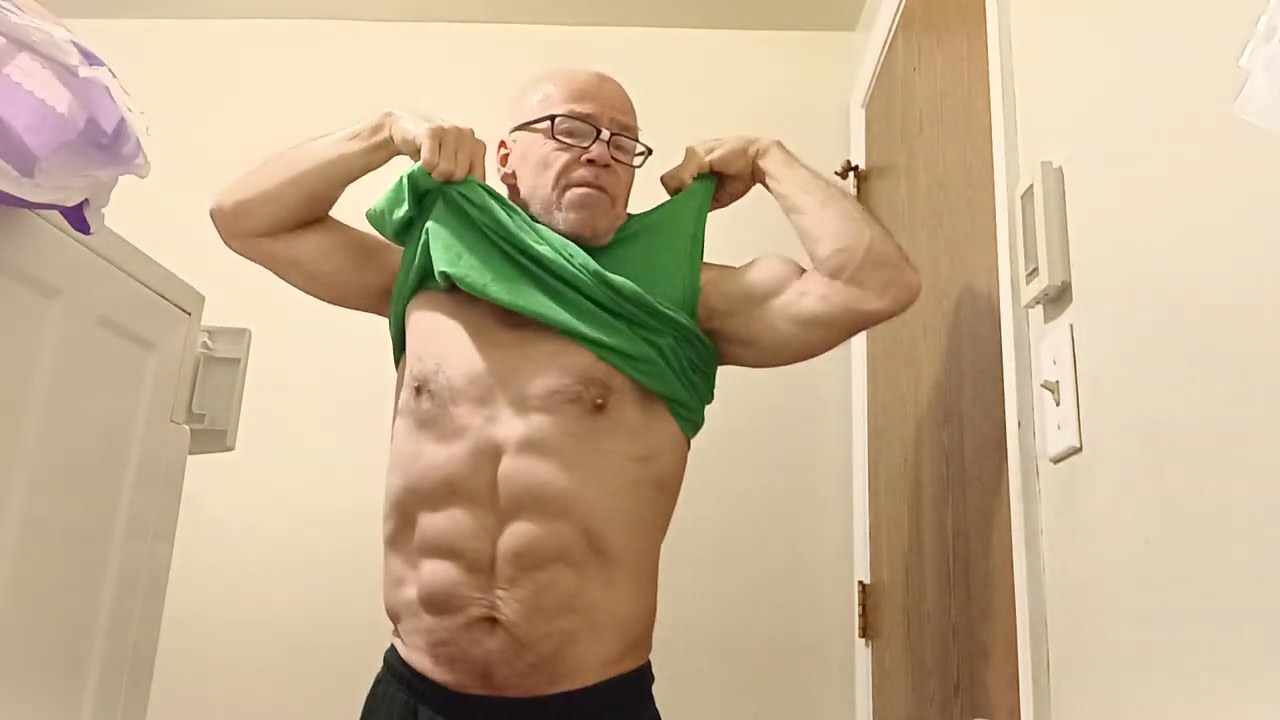 Мускулистый мужчина снимает рубашку