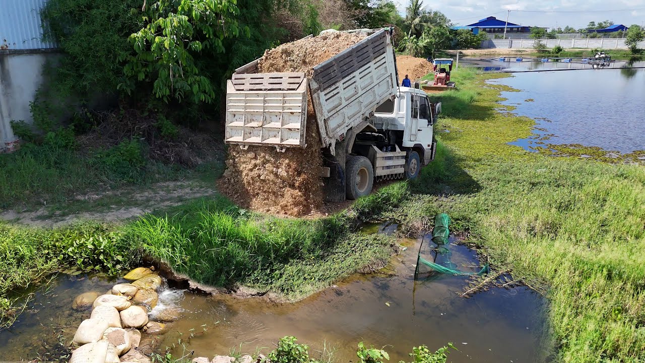 Start A New Landfill Project!Dump Truck Pouring soil into the water build road, Dozer D20P Pushing