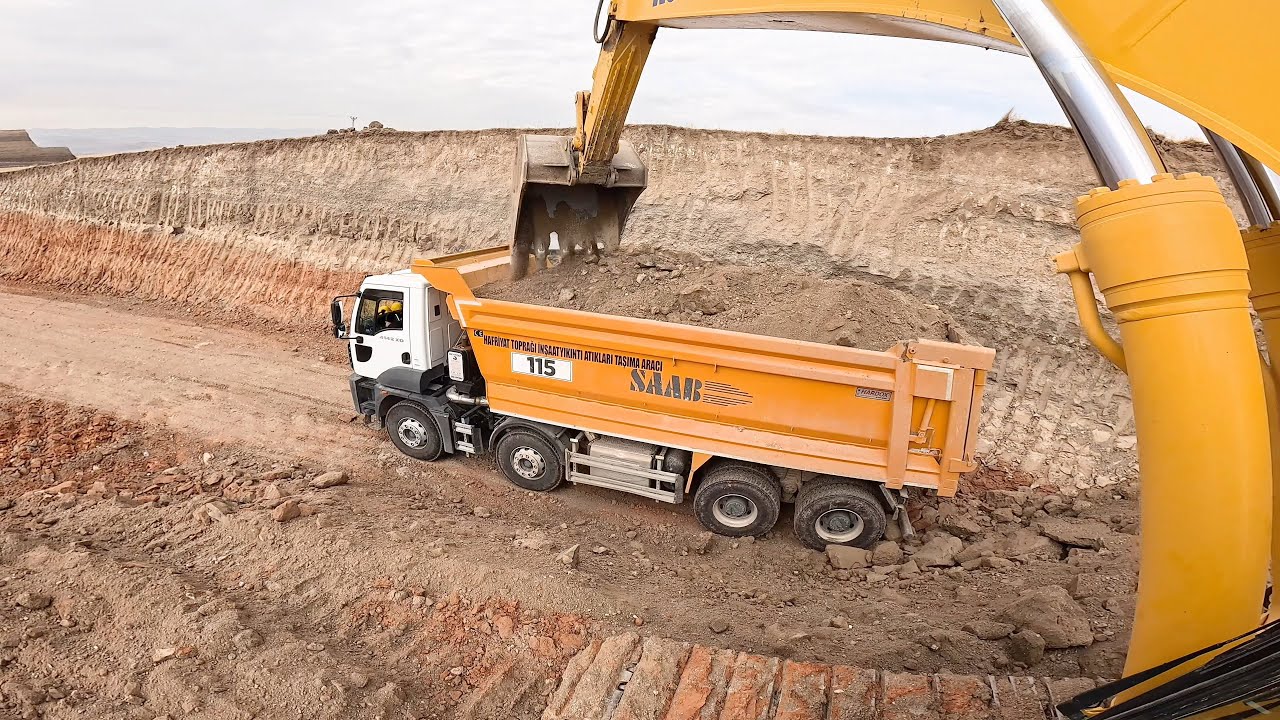 Komatsu Excavator loading sand in two directions.
