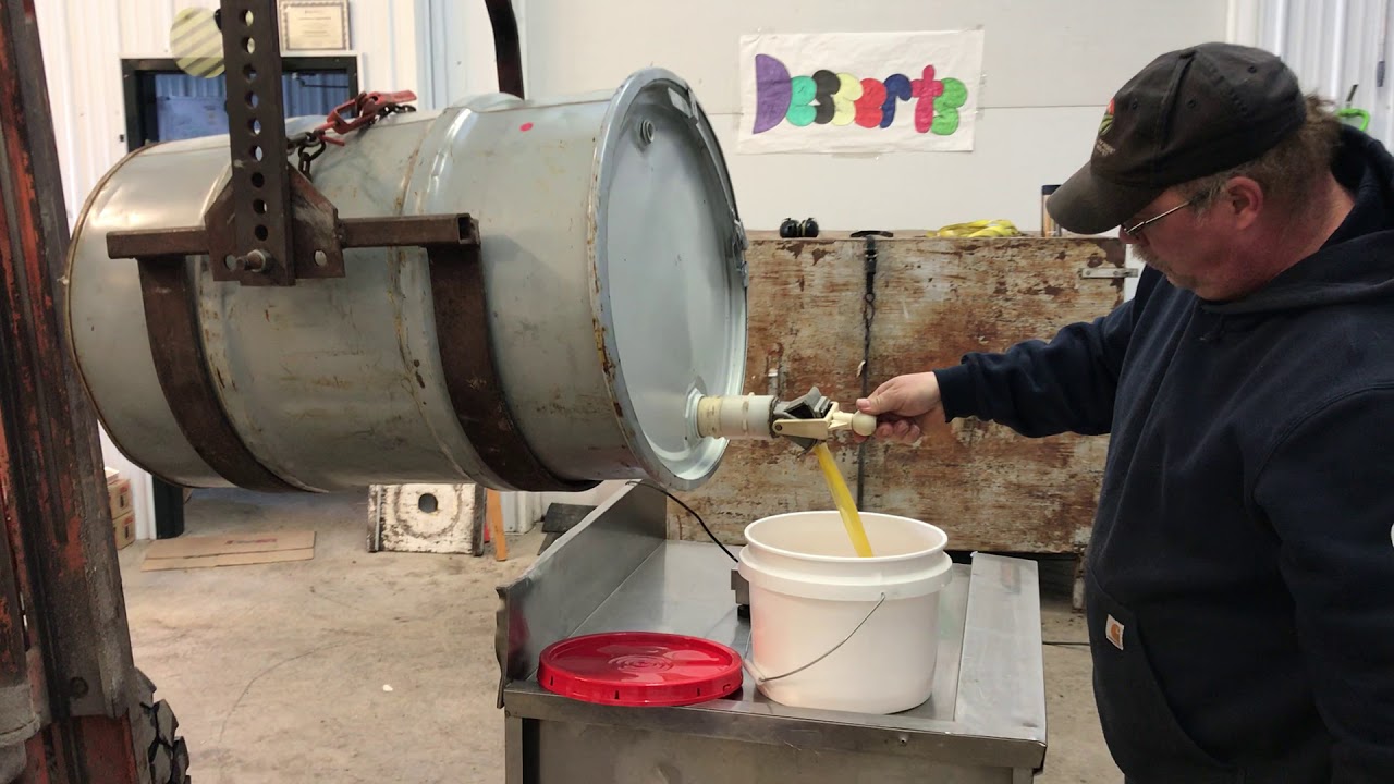 Tipping and tapping a honey barrel.