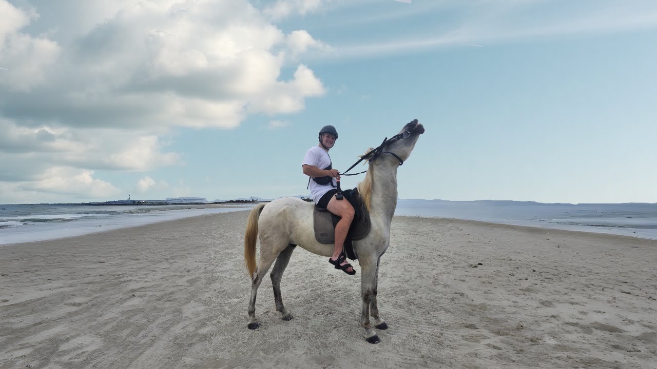 Riding a horse on a beach in Thailand.