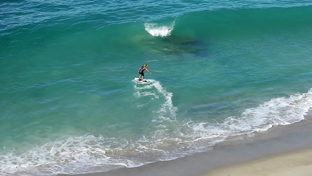 Professional Skimboarders Catching Waves Breaking Off A Rock - Raw Footage