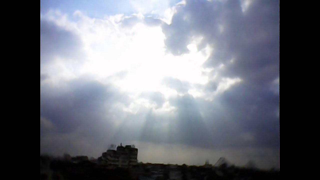 Crepuscular rays of light shining through clouds in the sky