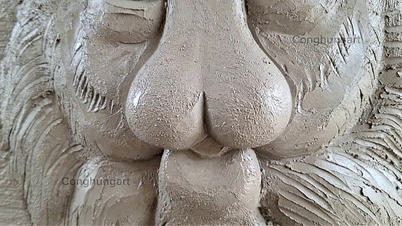 Making a tiger face relief out of cement.