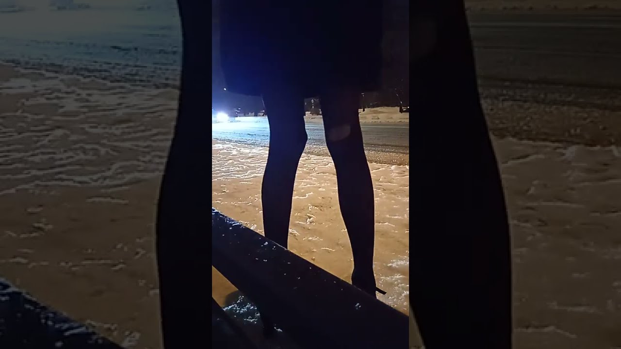 Crossdresser at bus stop, waiting for taxi in stockings and mini skirts, high hells. Public walking