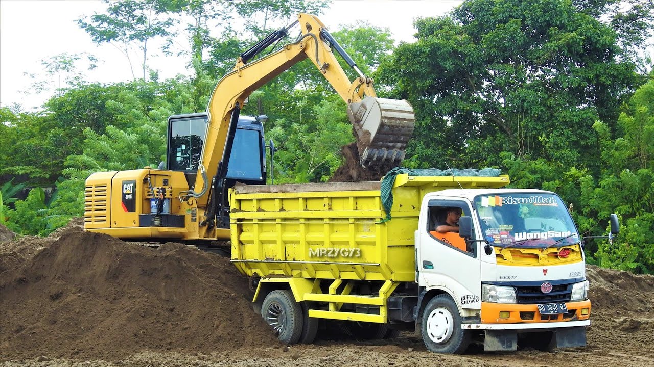 Mini Excavator CAT 307E And Dump Truck Moving Dirt