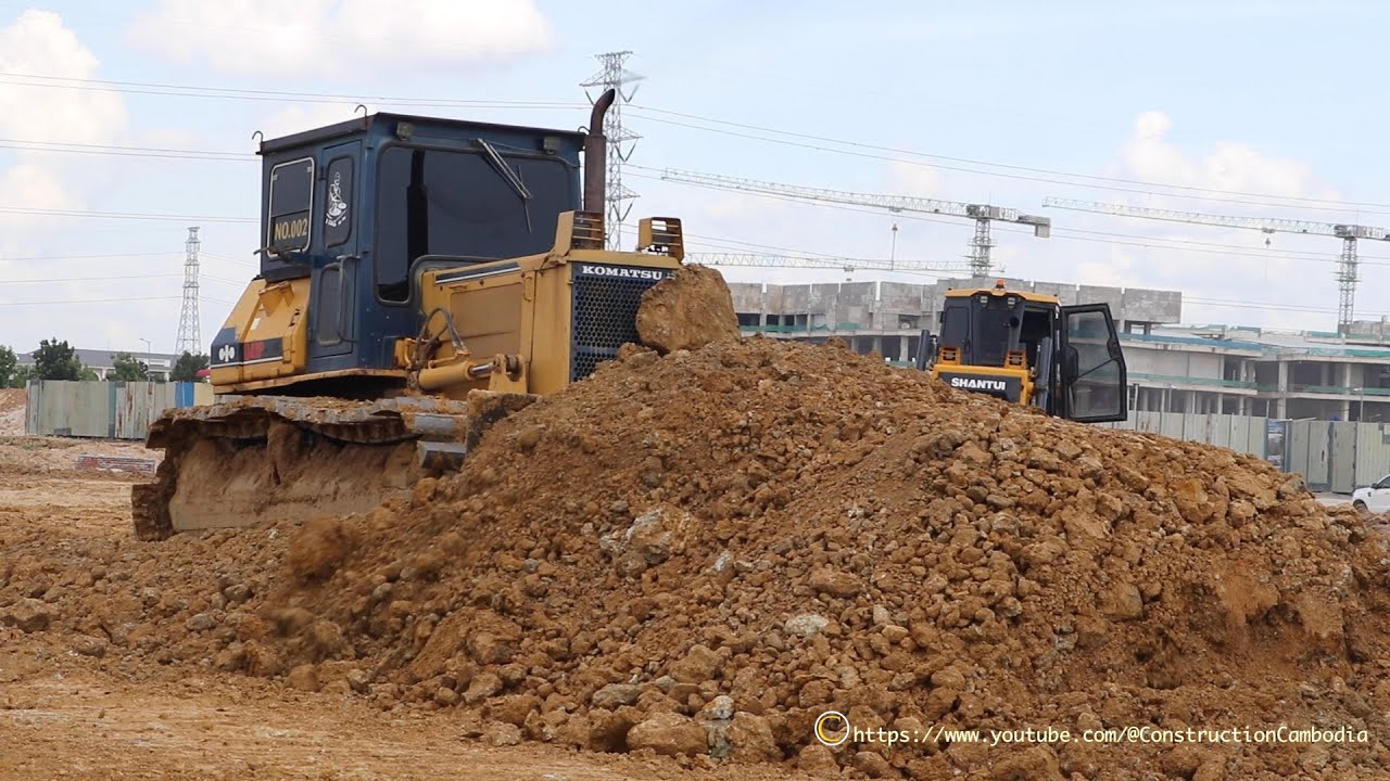 Bulldozer pushing leveling the soil And Dump Truck pouring Extra soil injection In the project