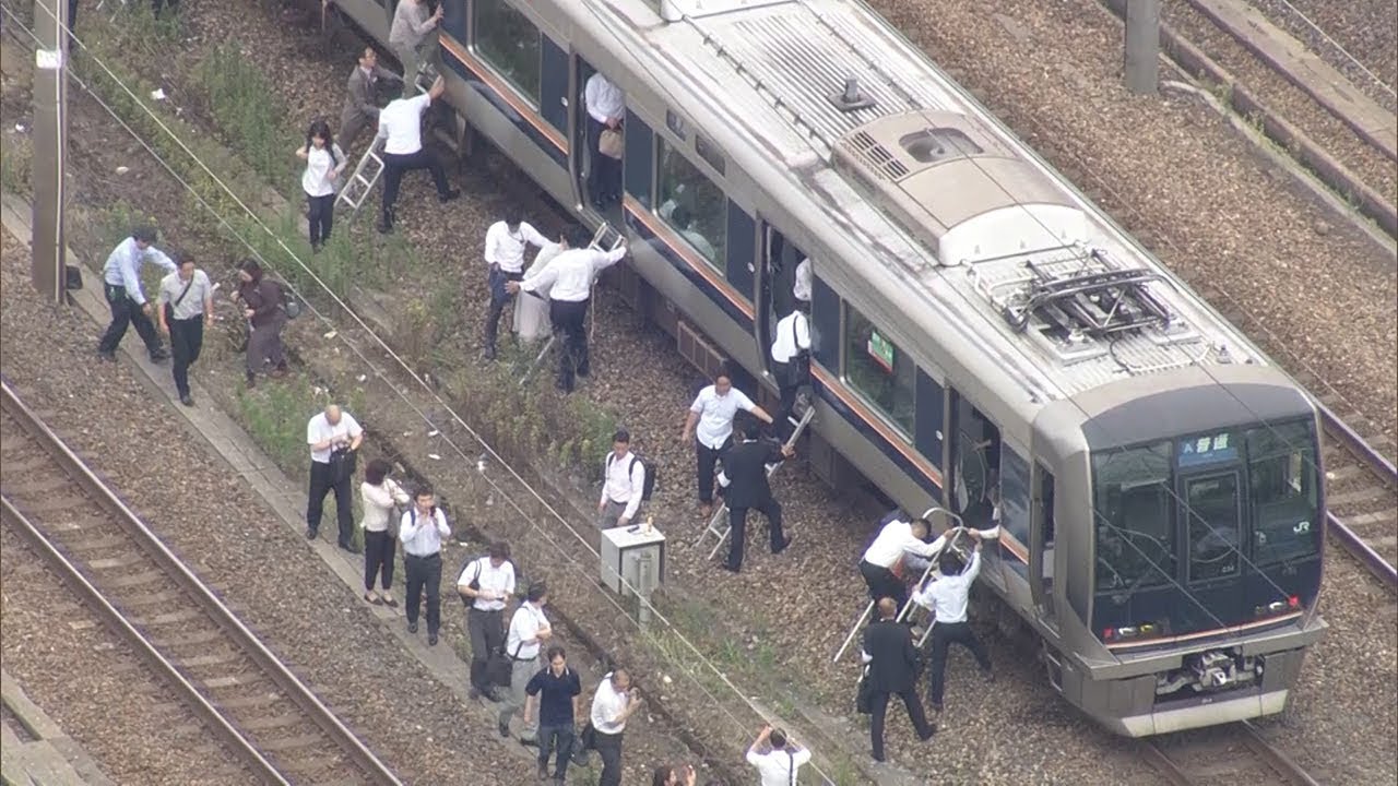 大阪北部地震で線路を歩いて駅に向かう乗客