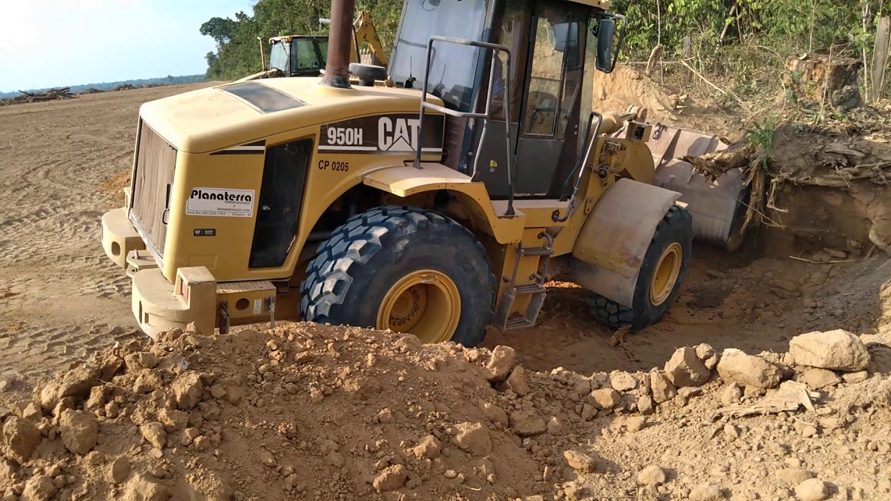 pá carregadeira arrancando toco