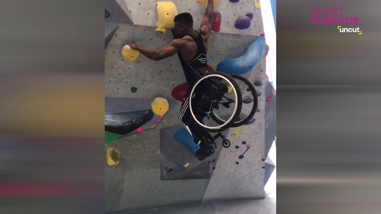 Man in wheelchair scales climbing wall