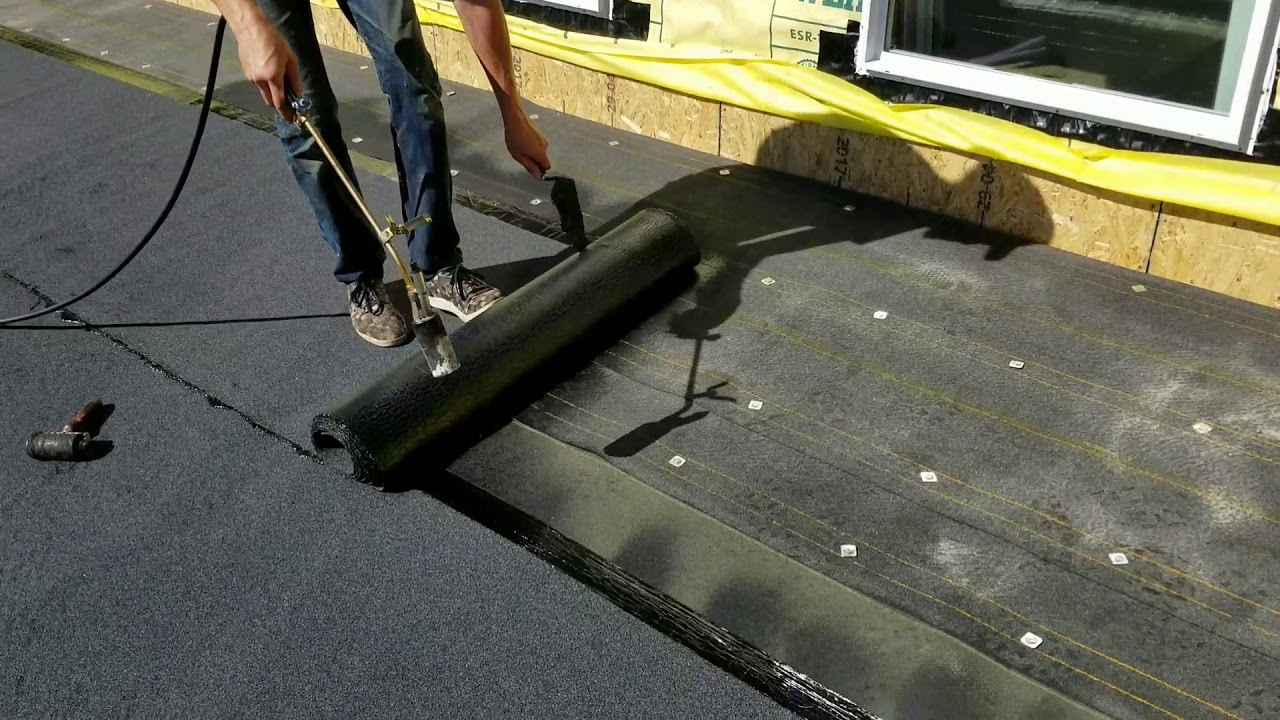 Estimator Sam installing torch down roofing