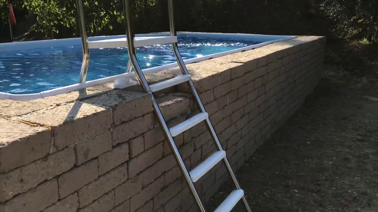 Piscina fuori terra Aqvam con rivestimento in blocchi di tufo