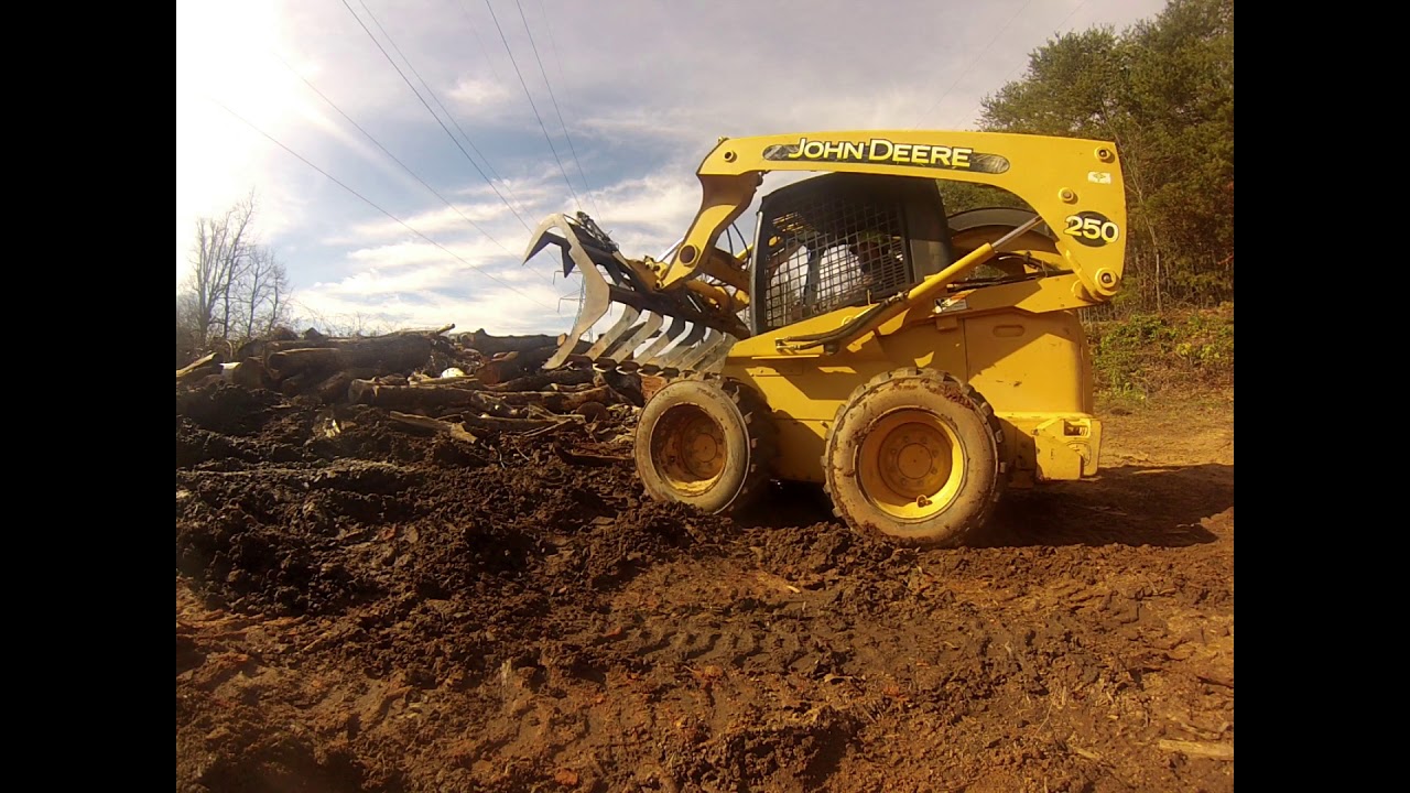 john deere 250 Skid steer moving logs and debris