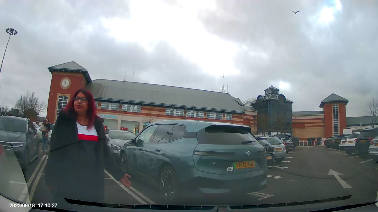 Woman stands in parking space to reserve a spot