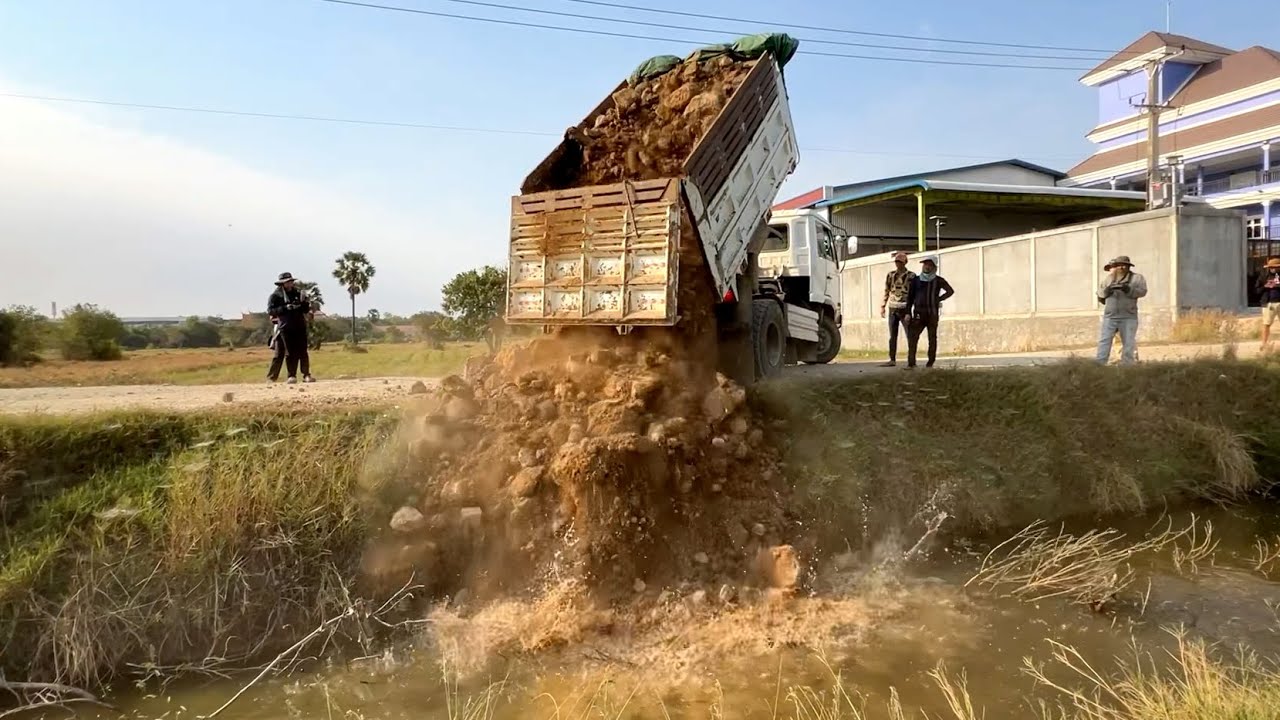 Let’s New project landfill by dump truck unloading soil and Bulldozer D20P working push soil filling