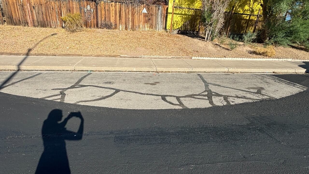 Henderson paved roads around cars left on street, leaving gaps in asphalt