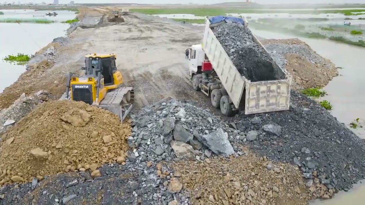 Nice Extreme Dump Truck Transport Stone with Operator Bulldozer Push Stone Building Road On Big Lake