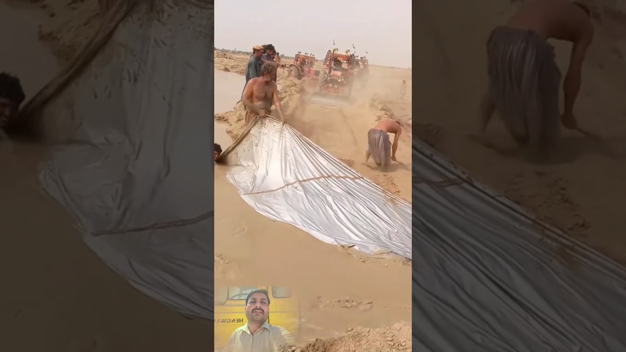 Gaon ko selab ke pani se bachane ki koshash trector se band laga rahe lican pani phar bhi tot gaya