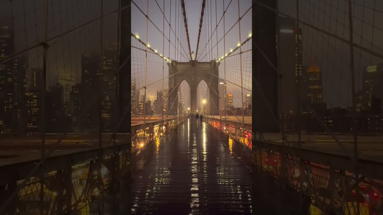 Crossing the iconic Brooklyn Bridge on a rainy evening in New York City