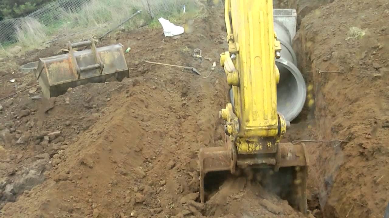 Excavator digging and laying 1500mm storm water pipes.