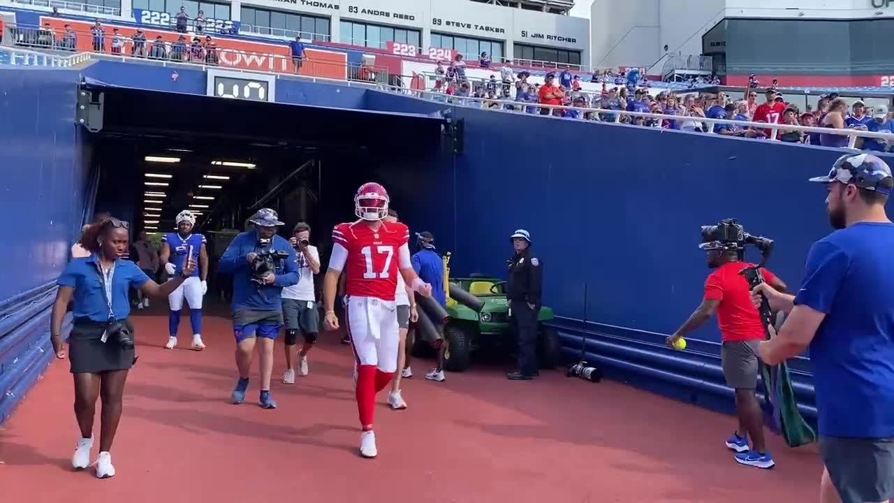 Josh Allen enters practice in a red helmet