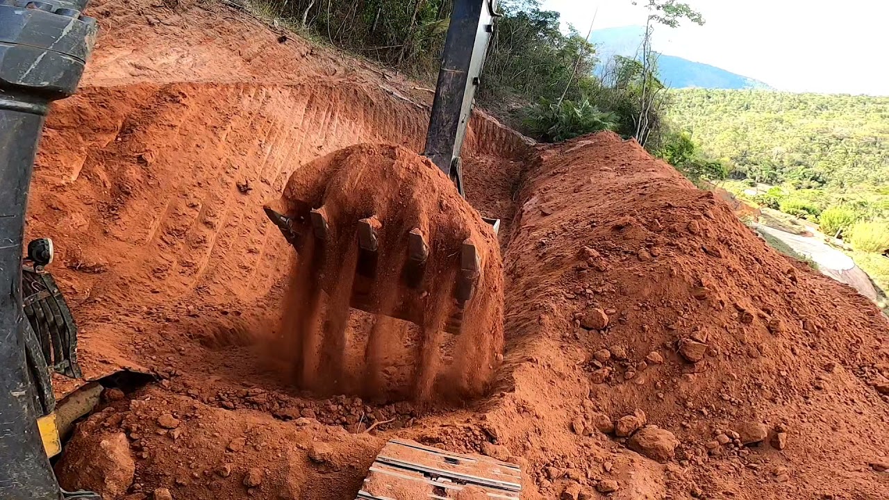 escavadeira John Deere 130g fazendo acabamento de rampa riscada,gravado do ângulo externo da máquina