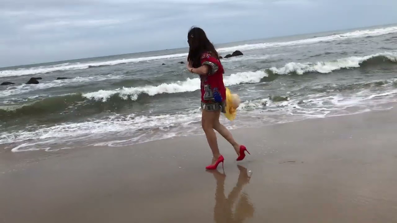 wide playing on the beach with red high heels