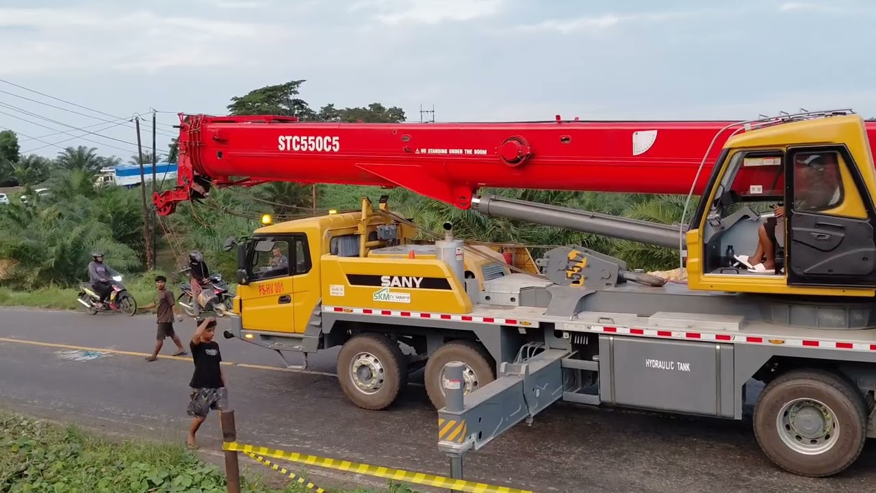 Evakuasi truk trailer menggunakan boom crane.